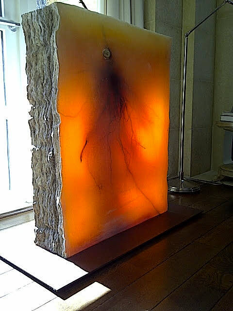 Square section of amber tinted glycerin with a tree limb inside, small branch poking out at the top.